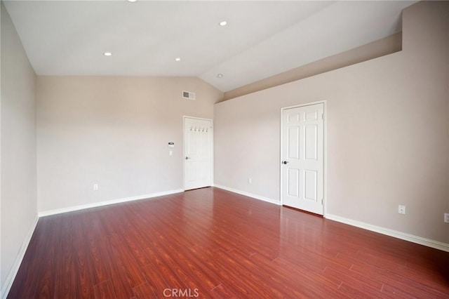 unfurnished room featuring vaulted ceiling, baseboards, and wood finished floors