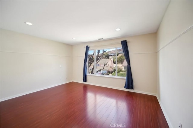 spare room featuring recessed lighting, wood finished floors, visible vents, and baseboards