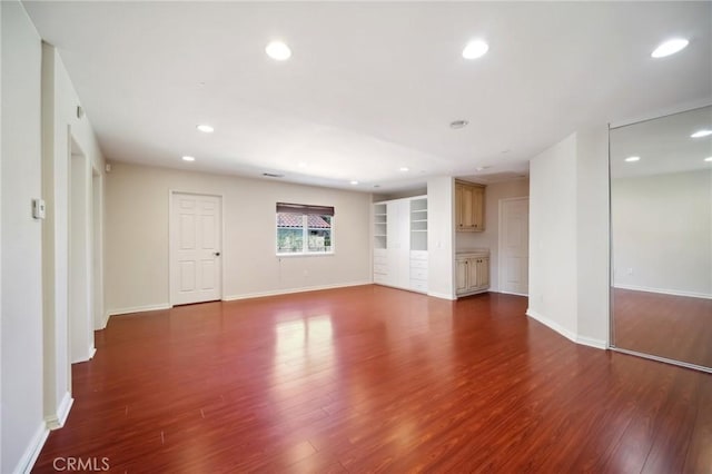 empty room featuring baseboards, wood finished floors, and recessed lighting