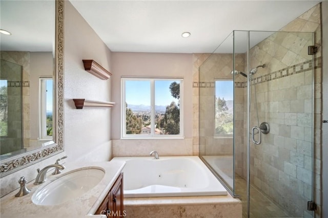 bathroom featuring a jetted tub, vanity, and a stall shower