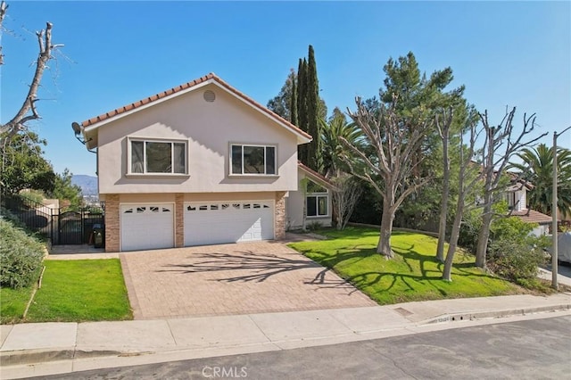 view of front of home with a front lawn, fence, an attached garage, stucco siding, and decorative driveway