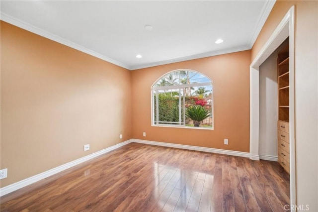 interior space with baseboards, crown molding, wood finished floors, and recessed lighting