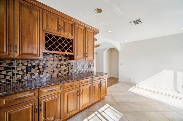 bar featuring arched walkways, visible vents, recessed lighting, decorative backsplash, and light tile patterned floors