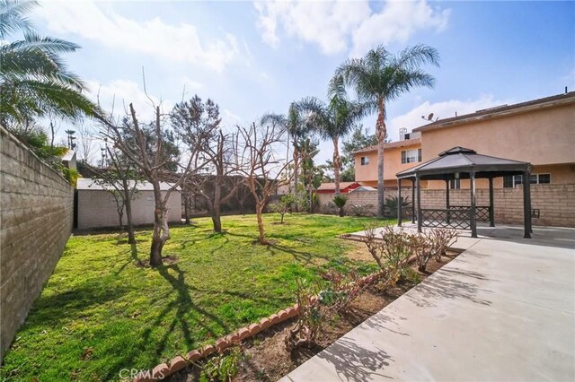 view of yard with a patio area, a fenced backyard, and a gazebo
