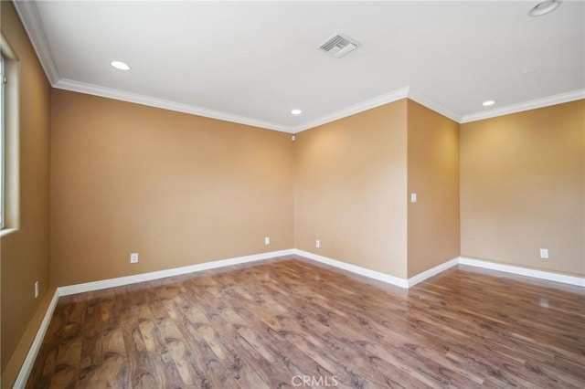 empty room with visible vents, baseboards, recessed lighting, wood finished floors, and ornamental molding