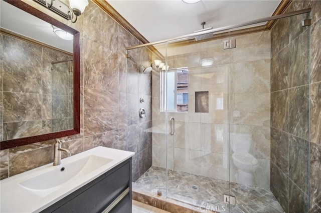 full bath featuring tile walls, vanity, and a stall shower