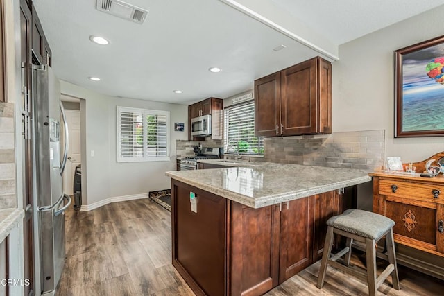 2752 Lemon Dr, Simi Valley, CA 93063 - kitchen featuring stainless steel appliances, a peninsula, backsplash, recessed lighting, and wood finished floors