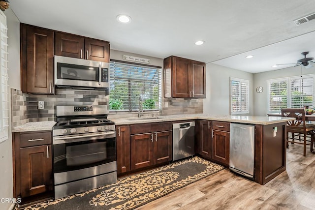 2752 Lemon Dr, Simi Valley, CA 93063 - kitchen featuring appliances with stainless steel finishes, a peninsula, light wood-type flooring, decorative backsplash, and a ceiling fan