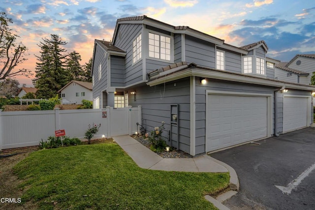 2752 Lemon Dr, Simi Valley, CA 93063 - property exterior at dusk with an attached garage, asphalt driveway, and a gate