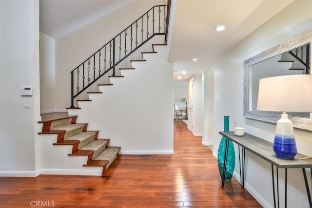 stairs with recessed lighting, baseboards, and wood finished floors