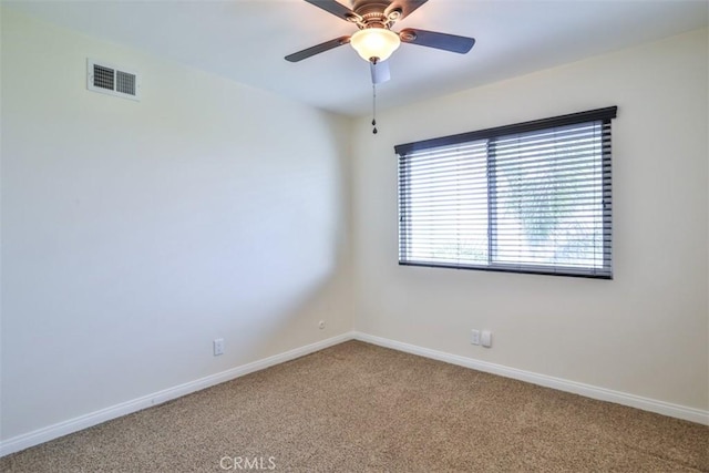 carpeted empty room with visible vents, baseboards, and ceiling fan