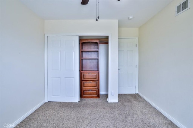 unfurnished bedroom featuring carpet flooring, ceiling fan, baseboards, visible vents, and a closet