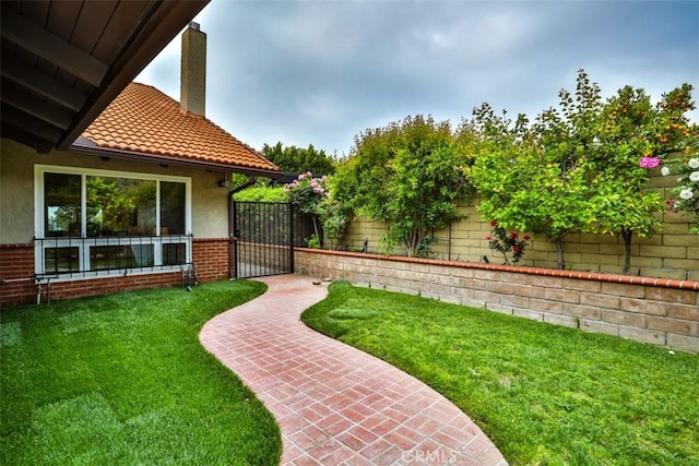 view of yard featuring a fenced backyard and a gate