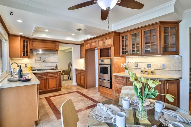 kitchen with brown cabinets, a sink, a warming drawer, stainless steel appliances, and extractor fan
