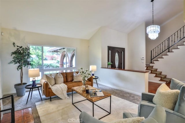 carpeted living area featuring baseboards, stairs, high vaulted ceiling, and a notable chandelier