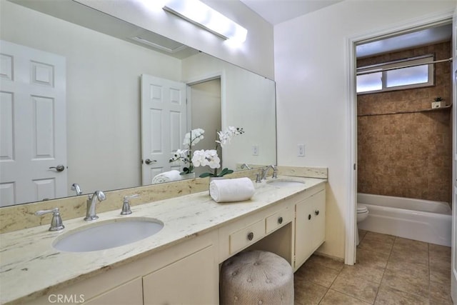 bathroom with double vanity, a sink, tile patterned floors, and toilet