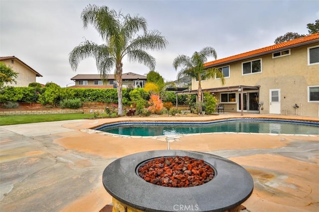 pool with a patio and a fire pit