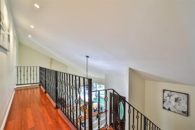 hallway with recessed lighting, baseboards, wood finished floors, and lofted ceiling