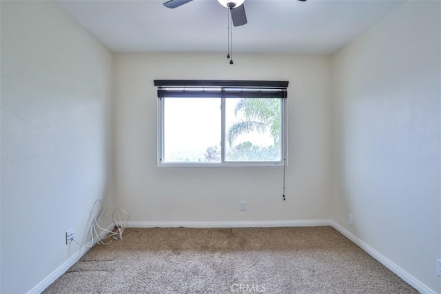 carpeted empty room with baseboards and a ceiling fan