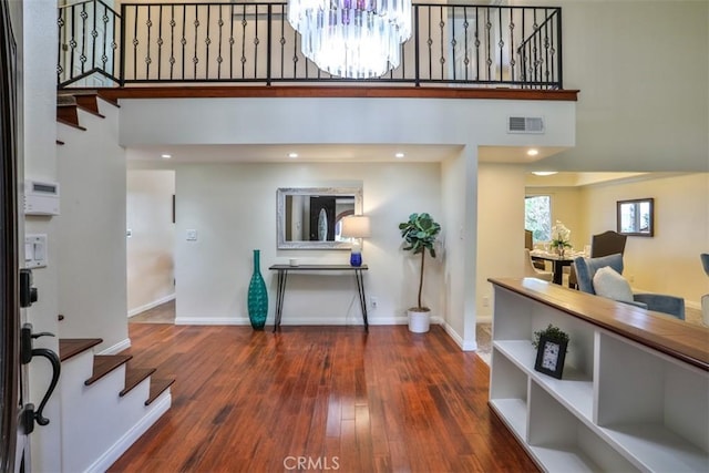 entryway with a towering ceiling, baseboards, and a chandelier