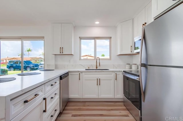 kitchen with stainless steel appliances, white cabinets, and a sink