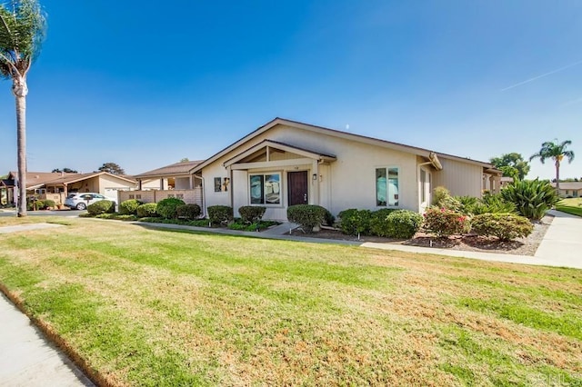 ranch-style house with a front yard and stucco siding
