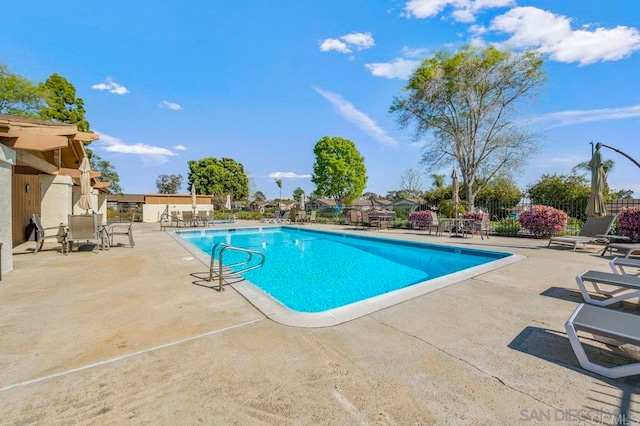 pool featuring fence and a patio