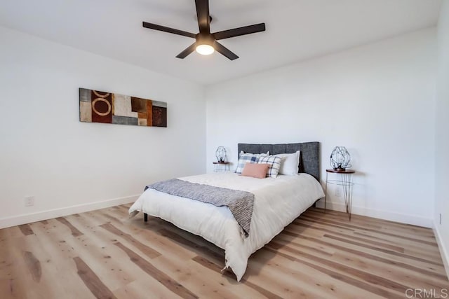 bedroom featuring light wood-style flooring, baseboards, and ceiling fan