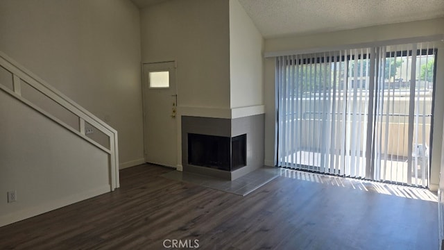 13104 Glen Ct Unit 46, Chino Hills, CA 91709 - unfurnished living room featuring a multi sided fireplace, a textured ceiling, baseboards, and wood finished floors