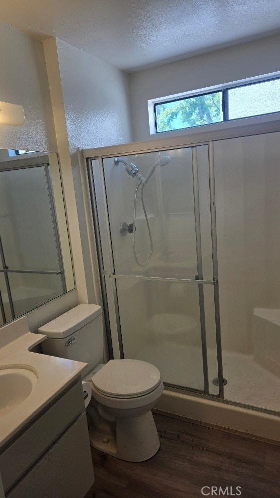 13104 Glen Ct Unit 46, Chino Hills, CA 91709 - bathroom featuring vanity, wood finished floors, toilet, a textured ceiling, and a shower stall