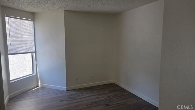 13104 Glen Ct Unit 46, Chino Hills, CA 91709 - unfurnished room with a textured ceiling, baseboards, and dark wood-type flooring