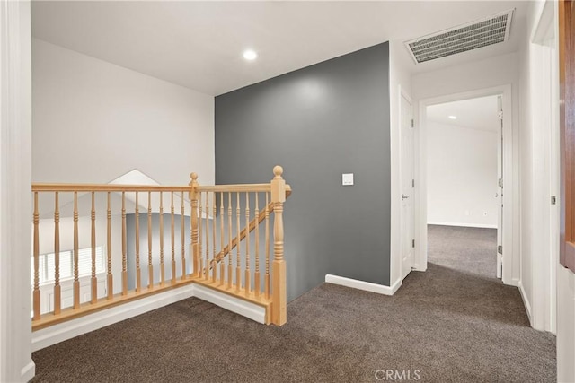 corridor with baseboards, recessed lighting, visible vents, an upstairs landing, and dark carpet