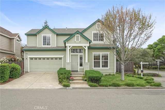 view of front of home with a garage, roof with shingles, concrete driveway, and fence