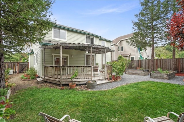 rear view of house with a pergola, a fenced backyard, a yard, a wooden deck, and a garden