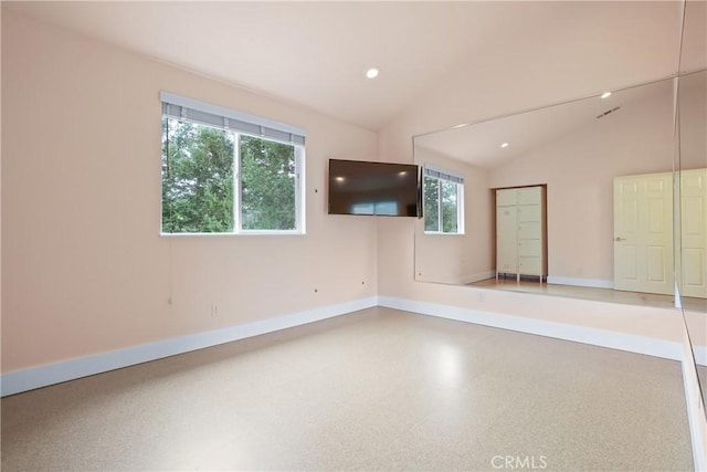 spare room featuring lofted ceiling, baseboards, and recessed lighting