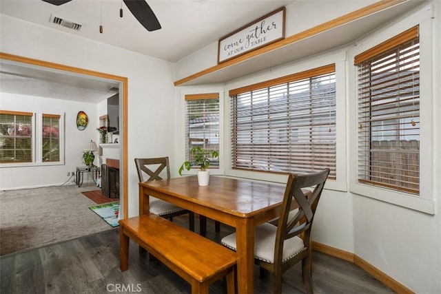 3432 N Arrowhead Ave, San Bernardino, CA 92405 - dining room featuring a ceiling fan, dark wood-style flooring, baseboards, and a fireplace with flush hearth