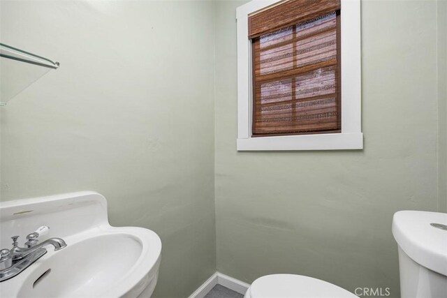 3432 N Arrowhead Ave, San Bernardino, CA 92405 - half bath featuring toilet, a sink, and baseboards