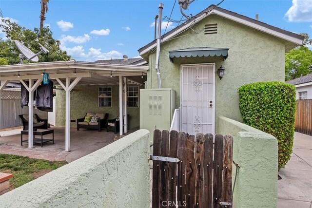 3432 N Arrowhead Ave, San Bernardino, CA 92405 - view of front of property with stucco siding, outdoor lounge area, a patio area, and a gate