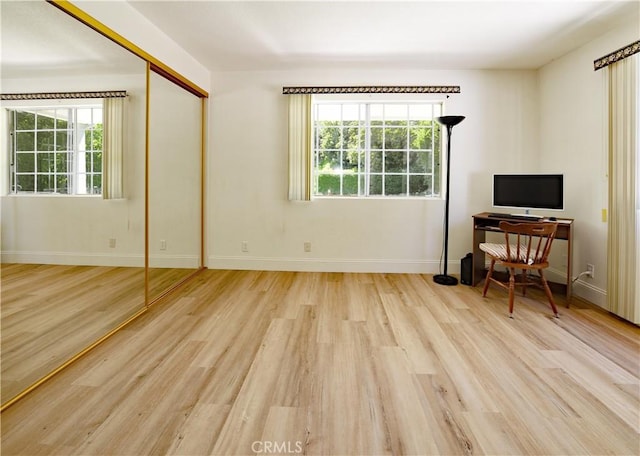 living room featuring wood finished floors, baseboards, and plenty of natural light