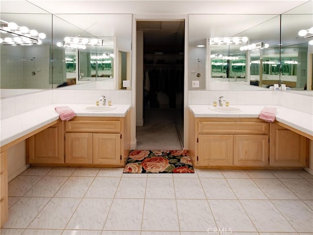 full bath with a tile shower, two vanities, decorative backsplash, and a sink
