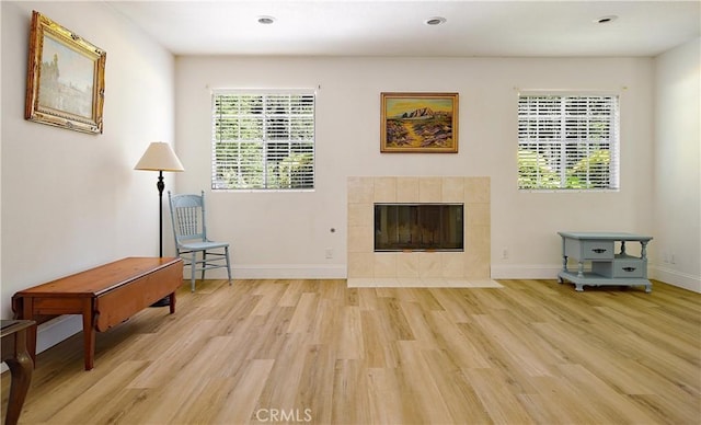 living room with recessed lighting, baseboards, light wood finished floors, and a fireplace