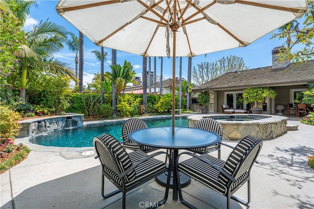 view of pool with a patio area, outdoor dining space, and a pool with connected hot tub