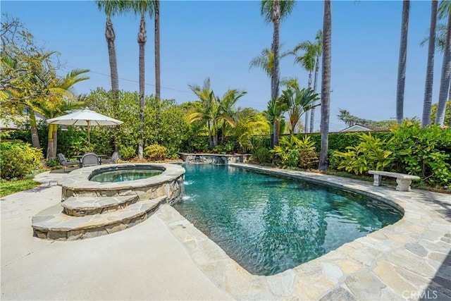 pool with a patio area and an in ground hot tub