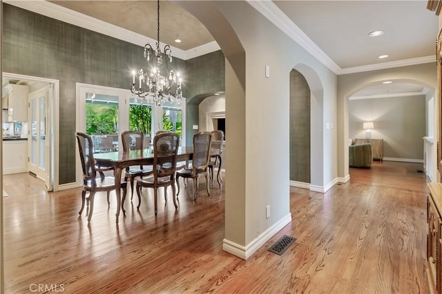 dining space with light wood finished floors, visible vents, and ornamental molding