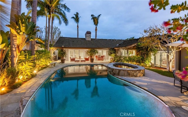 view of swimming pool with a patio area, french doors, and a pool with connected hot tub