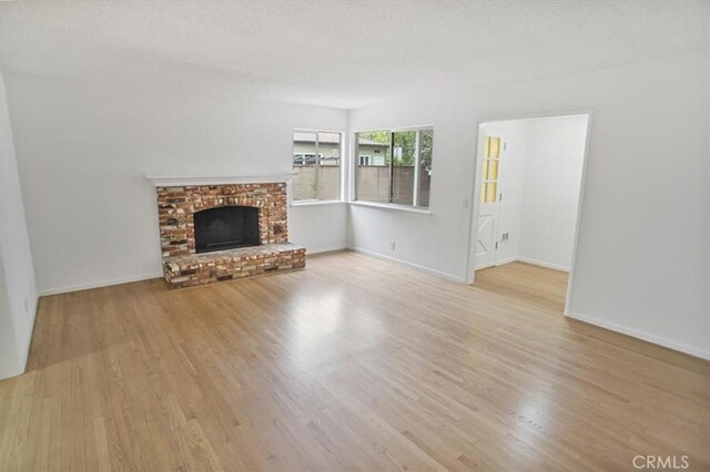 6833 Sultana Ave, San Gabriel, CA 91775 - unfurnished living room with wood finished floors and a brick fireplace