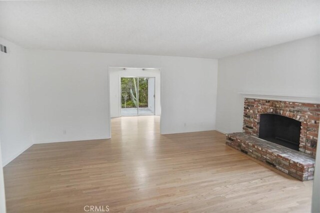 6833 Sultana Ave, San Gabriel, CA 91775 - unfurnished living room featuring wood finished floors, a fireplace, and a textured ceiling