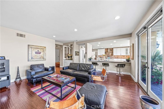 living area with visible vents, wood-type flooring, and recessed lighting
