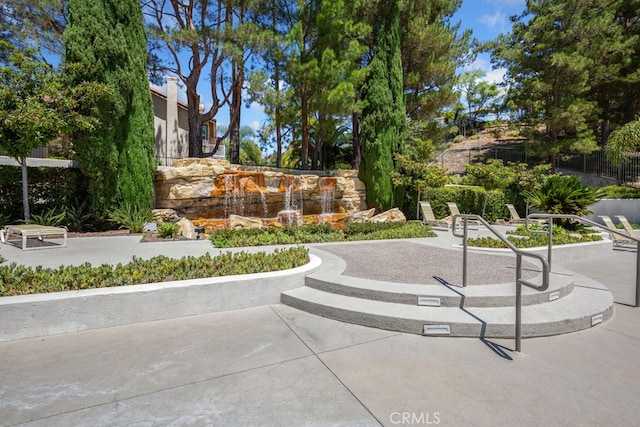 view of property's community with fence and a patio