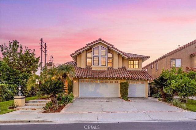 view of front of house featuring concrete driveway, a garage, stucco siding, and a tiled roof